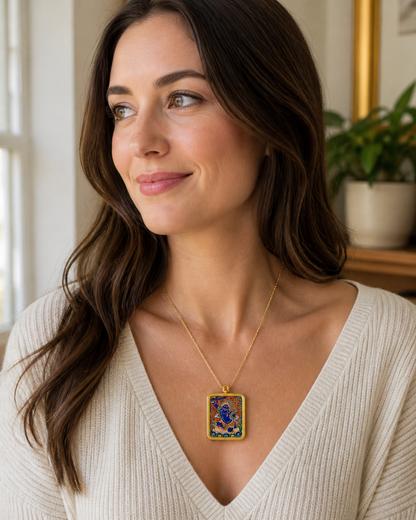 Woman wearing an AURESTAR Acalanatha thangka pendant with a white top.