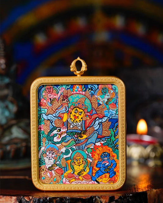 Close-up of a Vaishravana thangka pendant with a gold-toned copper case.