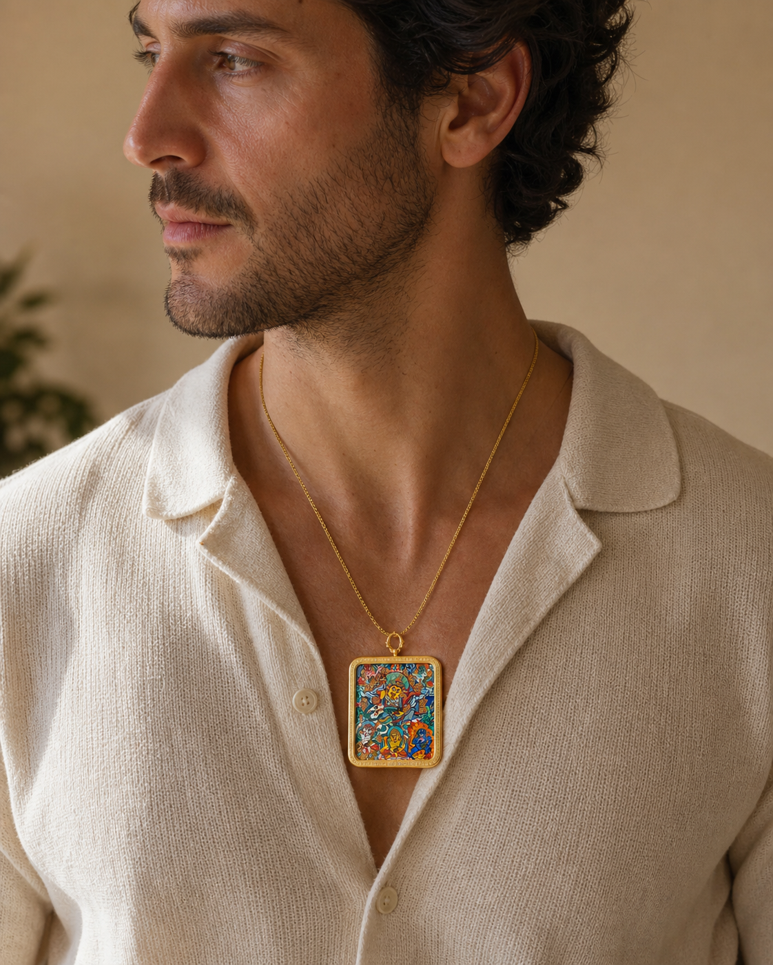 Man wearing an AURESTAR Vaishravana thangka pendant with a cream shirt.