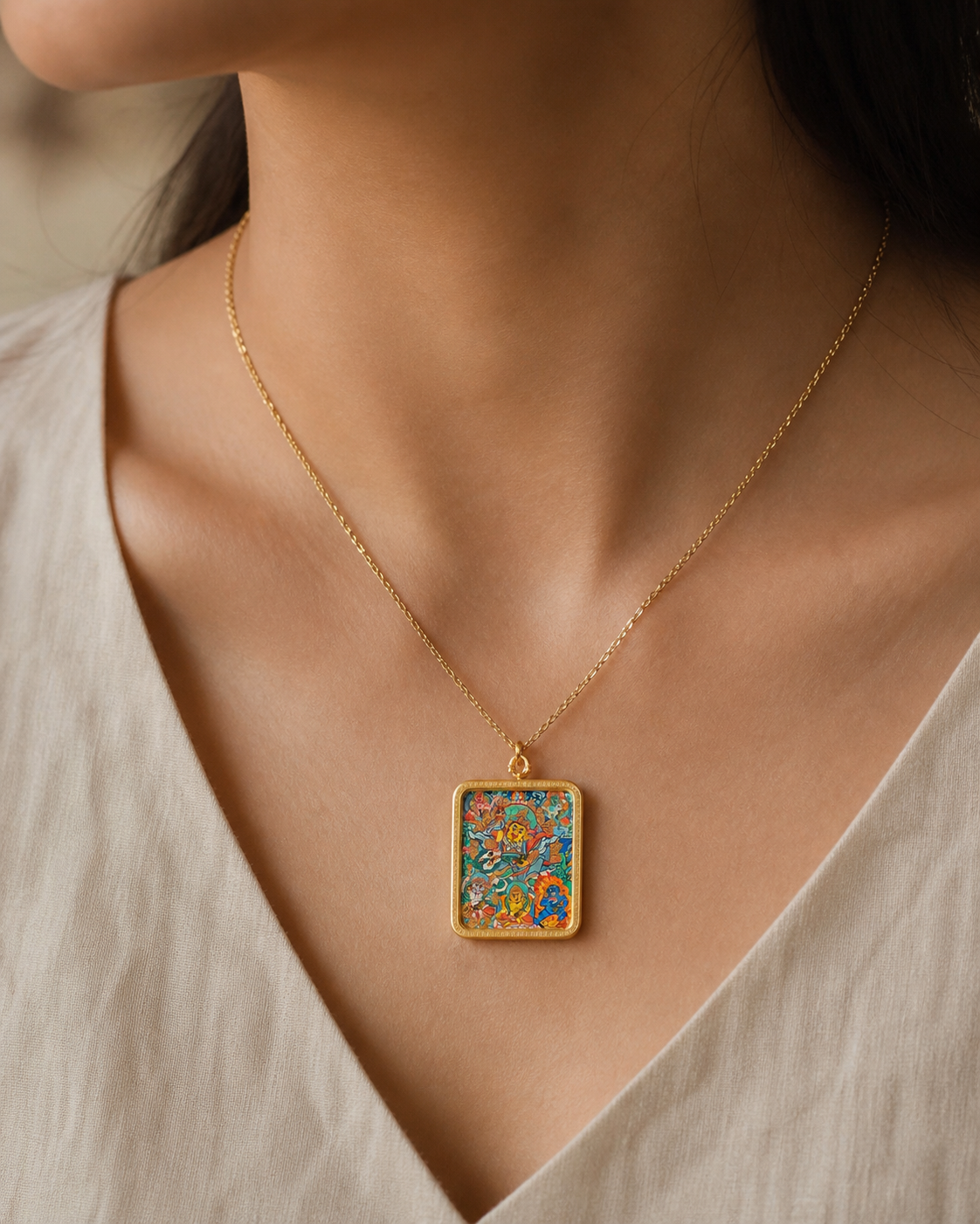 Close-up of an AURESTAR Vaishravana thangka pendant being worn.